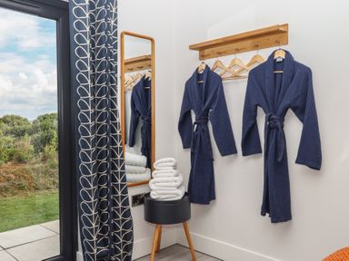 A bathroom with bathrobes and towels at The Cadeleigh near Tiverton