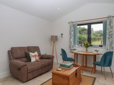 A snug with a sofa and table at The Pennymoor in Cadeleigh near Tiverton