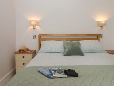 A bedroom with a bed and nightstand at The Pennymoor in Cadeleigh near Tiverton