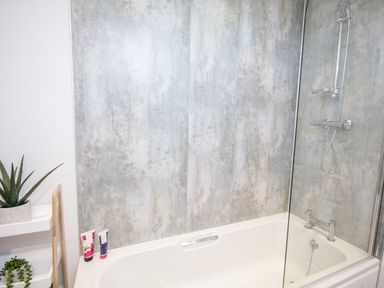 A bathroom with a bathtub shower screen and wall mounted shower at 14 Parc Delfryn Brynteg near Benllech