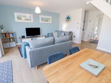 A living room with sofas a television and a dining table at 14 Parc Delfryn Brynteg near Benllech