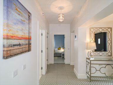 A hallway with patterned floor tiles a console table with a lamp and mirror and a painting on the wall at Wee Andy's in Slavary near Buncrana County Donegal