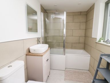 A bathroom with a toilet sink bathtub and shower at Ysgoldy Brynwyre Llanrhystud