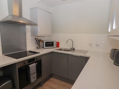 A kitchen with an oven stovetop microwave sink and counter space at 21 Coedrath Park Saundersfoot