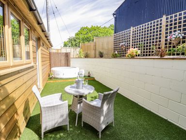 An outdoor area with two chairs and a small table on artificial grass and a white inflatable hot tub at FAIRFIELD in Clee Hill