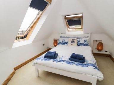 A bedroom with a double bed under two skylight windows at Bwthyn Awel Church Bay near Cemaes Bay