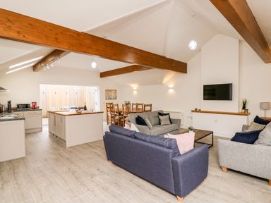 An open living space with kitchen island dining table and sofas at Bridgend Cottages in Howey near Llandrindod Wells