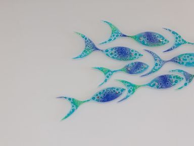 A wall decoration of blue and green fish shapes at Turquarze in Carbis Bay