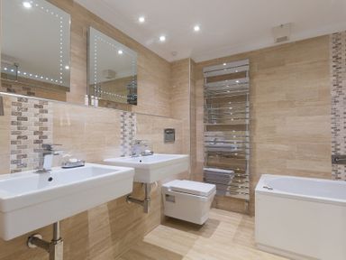 A bathroom with two sinks a toilet a bathtub and a heated towel rail at Turquarze in Carbis Bay