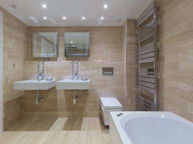A bathroom with two sinks two mirrors a toilet a bathtub and a wall-mounted towel radiator at Turquarze in Carbis Bay