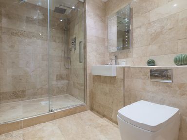 A bathroom with a glass shower enclosure a white sink a toilet and a mirror at Turquarze in Carbis Bay