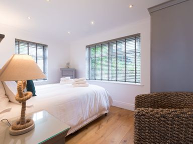 A bedroom with a bed and a lamp on a bedside table at Whitsunday House in Carbis Bay