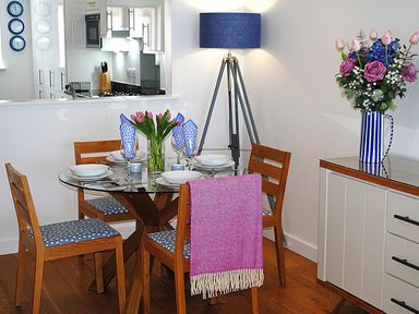 A dining room with a round table set for four at Sea Mist in Carbis Bay
