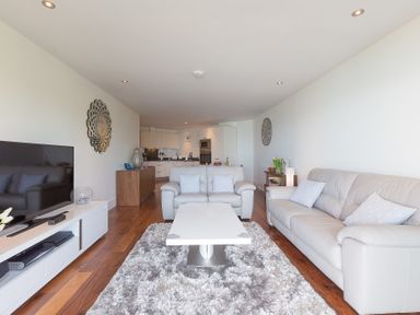 A living room with white sofas a white coffee table and a television at Abalone in St Ives