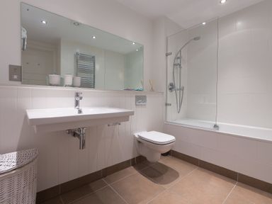 A bathroom with a sink mirror toilet bathtub and shower at Abalone in St Ives