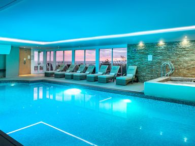 An indoor pool with lounge chairs and a spa at Abalone in St Ives