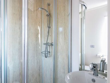 A bathroom with a shower enclosure sink with faucet and mirror at Oak Lodge in Glasshouse