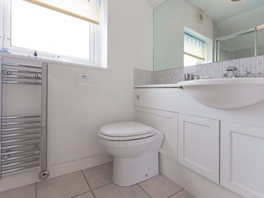 A bathroom with a toilet sink and towel radiator at Atlantic Blue in Carbis Bay