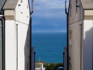 View of the ocean between two buildings with part of a balcony and car visible at Brinyloft in Carbis Bay