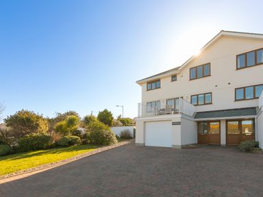 A driveway and a two story house with garage and windows and a garden at Cornerways in Carbis Bay