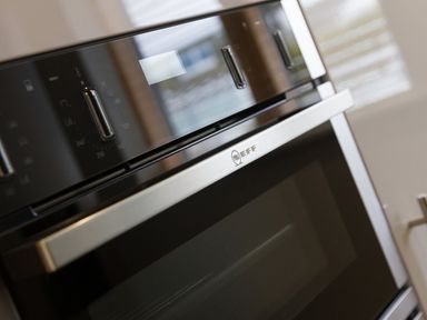 A close up of a built in oven with control knobs and a digital display at Elanora in Carbis Bay