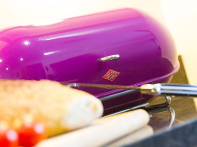 A purple Wesco bread box on a kitchen counter with bread and kitchen utensils in front at Elanora in Carbis Bay