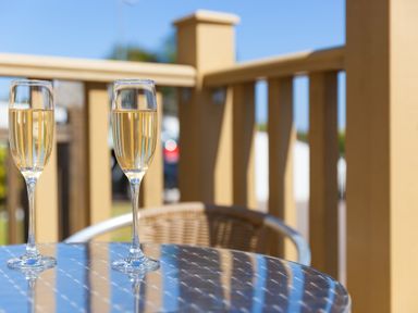 Two glasses of champagne on a round metal table on a balcony at Gennaker in Carbis Bay