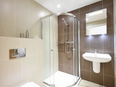 A bathroom with a corner shower unit sink and mirror at Halcyon Cove in Carbis Bay