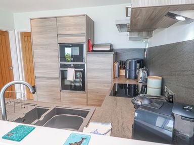 A kitchen with cabinets and appliances at Island View in Carbis Bay