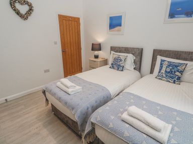 A bedroom with two beds and a lamp at Island View in Carbis Bay