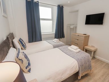 A bedroom with two beds and a television at Island View in Carbis Bay