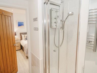 A bathroom with a shower and a door to the bedroom at Island View in Carbis Bay
