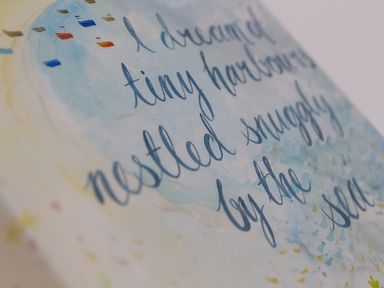 A close up of a watercolor painting with calligraphy text and small boats at Kernow's Dream in Carbis Bay