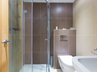 A bathroom with a corner shower enclosure a toilet and a sink at Kernow's Dream in Carbis Bay
