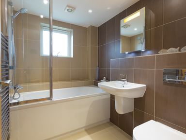 A bathroom with a bathtub shower sink mirror and toilet at Kernow's Dream in Carbis Bay