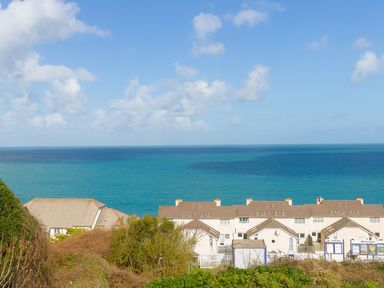 A view of the ocean with houses and greenery in the foreground at Kernow's Dream in Carbis Bay