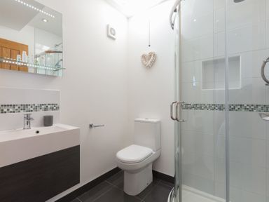 A bathroom with a sink a toilet and a shower with glass doors at Ocean Cove in Carbis Bay