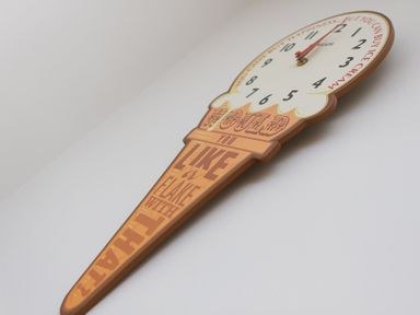 A wall clock shaped like an ice cream cone with text on the cone at Sapphire in Carbis Bay