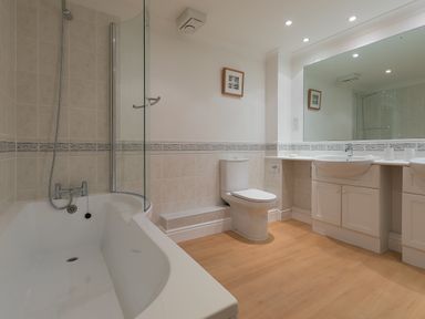 A bathroom with a bathtub shower toilet and double sink at Sapphire in Carbis Bay