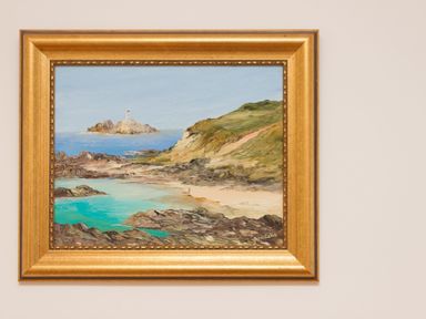 A framed painting of a coastal scene with a lighthouse on an island a beach and rocky shoreline