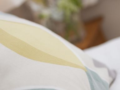 A close up of a pillow with yellow and blue shapes at Seathrift in Carbis Bay