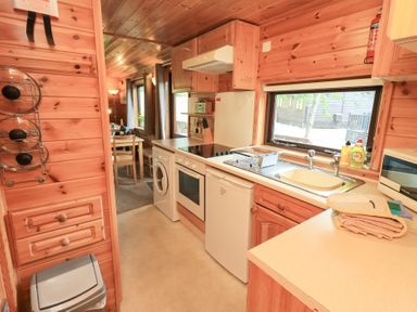 A kitchen with various appliances and a dining area at Squirrels Leap, Number 29, Burnside Park near Keswick