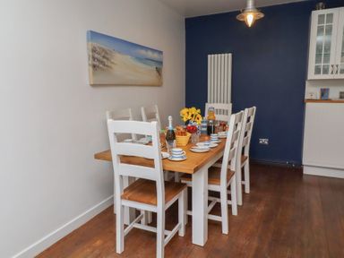 A dining room with a table set for meals at ASTA COTTAGE Cresswell