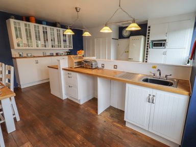 A kitchen with cabinets, sink, and appliances at ASTA COTTAGE in Cresswell