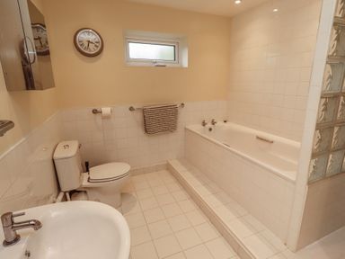 A bathroom with a bathtub, toilet, and sink at ASTA COTTAGE in Cresswell