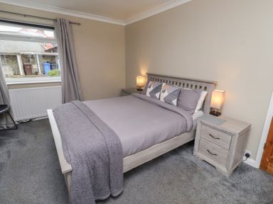 A bedroom with a bed and bedside tables at ASTA COTTAGE in Cresswell