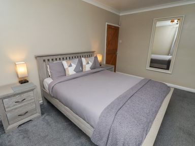 A bedroom with a bed and bedside tables at ASTA COTTAGE Cresswell