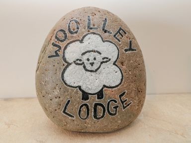 A stone with a drawing of a sheep and the words Woolley Lodge