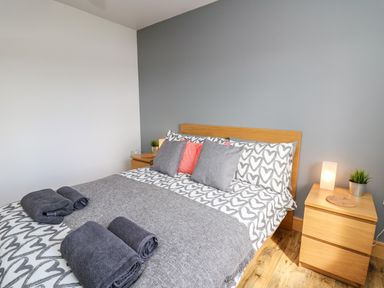 A bedroom with a double bed and bedside tables with lamps and plants at Llyn Cae Ty Nant Fishery Holiday Let Bwlchllan near Llangeitho