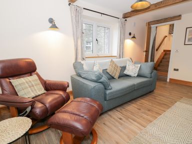 A living room with a sofa and recliner at Merddwr in Cerrigydrudion